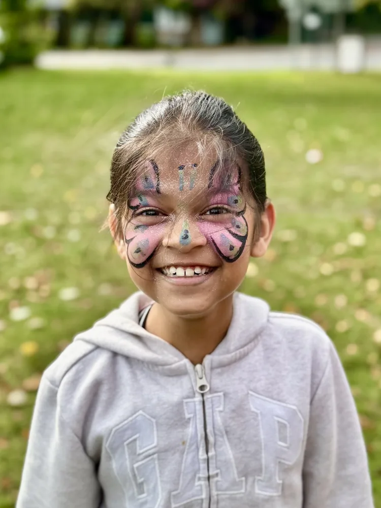 Nitara laughing with colourful face paint